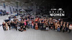 Large diverse group of women gathered in warehouse setting for Driven Women initiative event