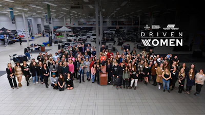 Large diverse group of women gathered in warehouse setting for Driven Women initiative event
