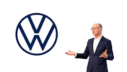 Businessman in navy suit presenting Volkswagen logo during corporate presentation