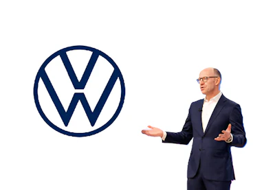 Businessman in navy suit presenting Volkswagen logo during corporate presentation