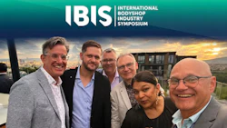 Six professionals posing together at sunset during the International Bodyshop Industry Symposium event