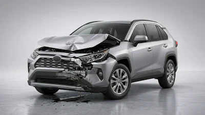 Silver Toyota RAV4 SUV with severe front-end collision damage and deployed airbags