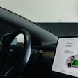 Tesla vehicle dashboard displaying charging status with 55-minute charge time and 202km range on center touchscreen