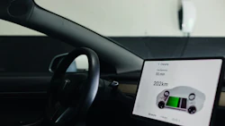 Tesla vehicle dashboard displaying charging status with 55-minute charge time and 202km range on center touchscreen