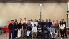 Group of diverse professionals posing together at an indoor event or conference gathering