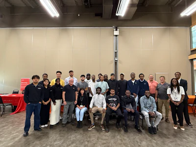 Group of diverse professionals posing together at an indoor event or conference gathering