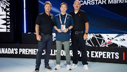 Three men standing on stage at CARSTAR Markham event, with center person holding an award