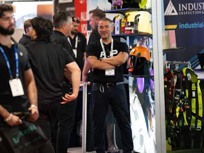 Professionals at industrial trade show booth discussing safety equipment and tools