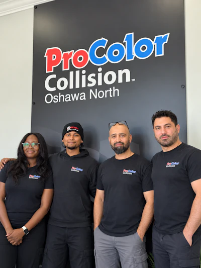 ProColor Collision Oshawa North team of four employees in branded apparel standing in front of company signage