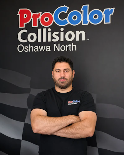 Professional man in ProColor Collision branded shirt posing against company backdrop