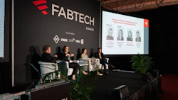 Panel discussion at FABTECH Canada conference with four speakers seated on stage before branded backdrop and projection screen