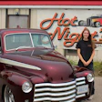 Woman posing beside burgundy vintage hot rod truck at Hot Night's Rods shop
