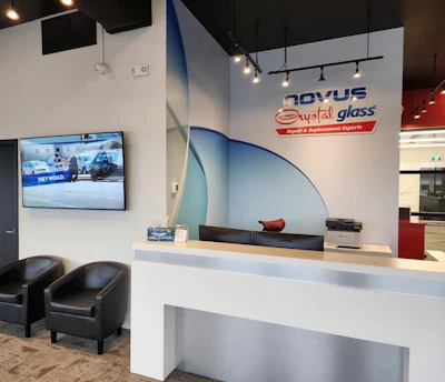 Novus Crystal Glass reception desk with blue curved wall design and branding in modern office space