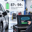 Technician checking electric vehicle battery health at 92% capacity using diagnostic tablet in service center