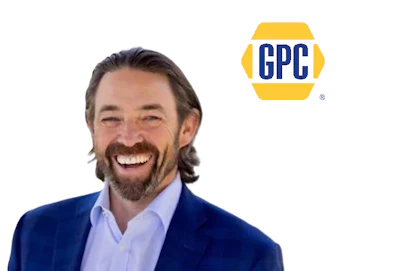 Professional man in navy blazer and light blue shirt smiling next to GPC logo