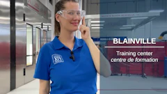 Woman in blue polo shirt at Blainville training center wearing safety glasses