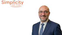 Professional headshot of a man in blue suit with Simplicity Car Care logo