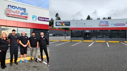 Auto glass repair shop storefront with five team members in black uniforms standing in front of the building entrance