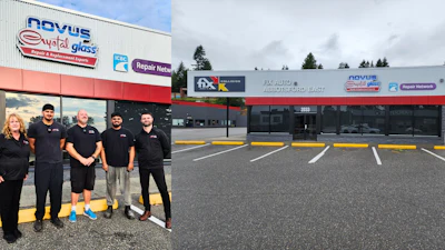 Auto glass repair shop storefront with five team members in black uniforms standing in front of the building entrance