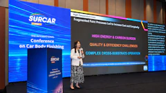 Female presenter at SURCAR International Conference on Car Body Finishing discussing high-temperature cure and paint processes