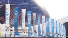 Multiple blue and white Appex branded banners hanging on stadium architecture with red graphic elements