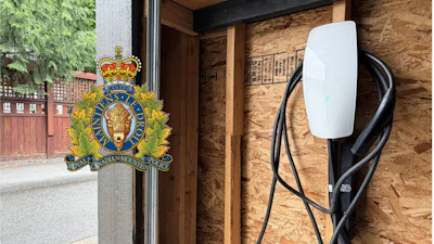 RCMP official crest mounted on wooden door frame with charging station visible