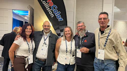 Five professionals wearing lanyards pose together at a corporate event with ProCool Coilsort branded signage