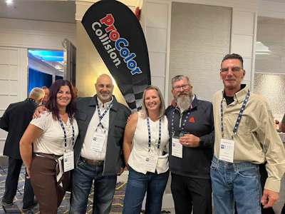 Five professionals wearing lanyards pose together at a corporate event with ProCool Coilsort branded signage