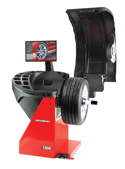 JBT B1200 wheel balancer with digital display monitor and mounted tire assembly