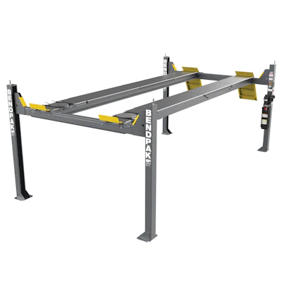 Bendpak four-post automotive lift with gray frame, yellow safety arms, and dual runway beams for vehicle service
