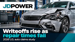 Damaged silver sedan in auto repair shop with JD Power headline about rising writeoffs and falling repair times
