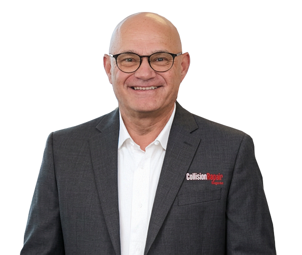 Professional headshot of a smiling man wearing glasses and gray blazer with white shirt Headshot