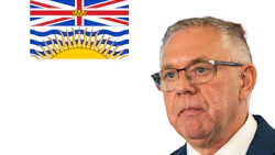 British Columbia flag alongside professional portrait of an older man in business attire wearing glasses