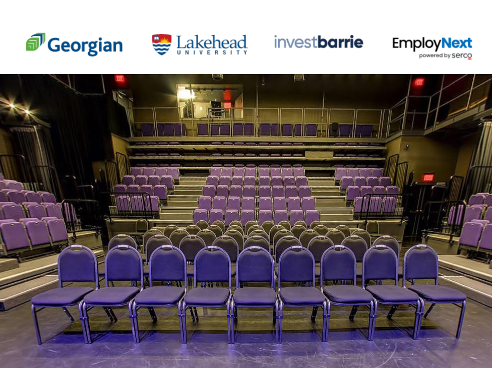 Empty auditorium with purple theater seats arranged in tiered rows on a beige stage floor