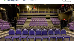 Empty auditorium with purple theater seats arranged in tiered rows on a beige stage floor