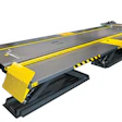 Yellow and black industrial car lift platform with gray deck and safety striping