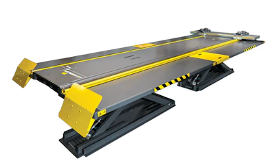 Yellow and black industrial car lift platform with gray deck and safety striping