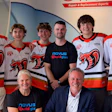 Team photo of young hockey players in red and white jerseys with adult staff members wearing NOVUS branded apparel