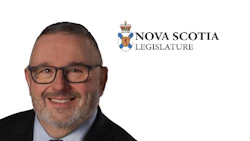 Professional headshot of a man wearing glasses and dark suit with Nova Scotia Legislature logo