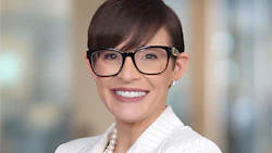 Professional headshot of a smiling woman wearing glasses and a white pinstriped blazer