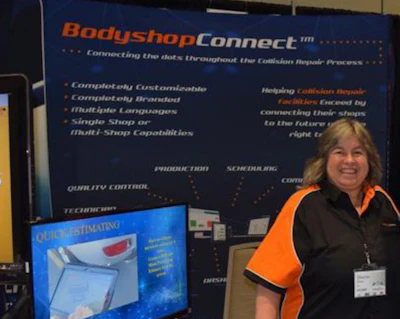 Woman presenting BodyshopConnect software solution at trade show booth with blue banner display