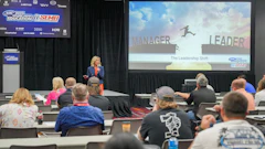 Professional speaker presenting 'The Leadership Shift' at SEMA education conference with audience seated at tables.