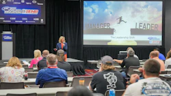 Professional speaker presenting 'The Leadership Shift' at SEMA education conference with audience seated at tables.