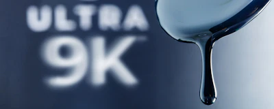 Ultra 9K liquid dripping from spoon against blue gradient background