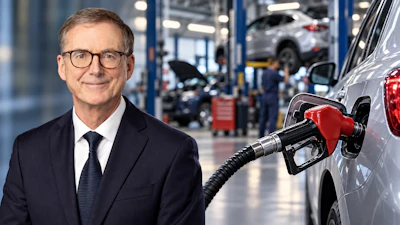 Professional man in business suit and glasses at automotive service center with vehicles and mechanics in background