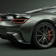 Silver high-performance sports car with red brake calipers and aerodynamic design photographed against neutral background