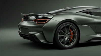 Silver high-performance sports car with red brake calipers and aerodynamic design photographed against neutral background