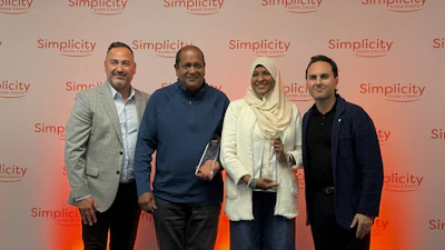 Four professionals posing together at a Simplicity branded corporate event with coral gradient backdrop