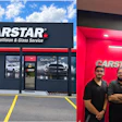 CARSTAR collision and glass service facility with storefront and three employees standing in front of red branded wall