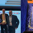 Three professionals receive Collision Centre of the Year award at conference with trophy and event signage